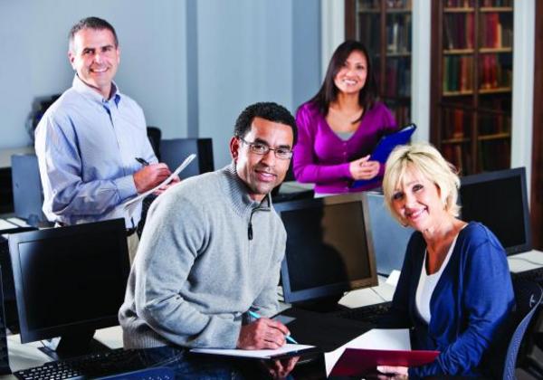 Two men and two women smiling in a library