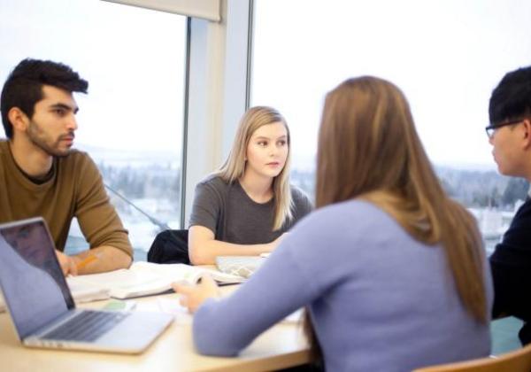 Male and female students working together in a meeting room